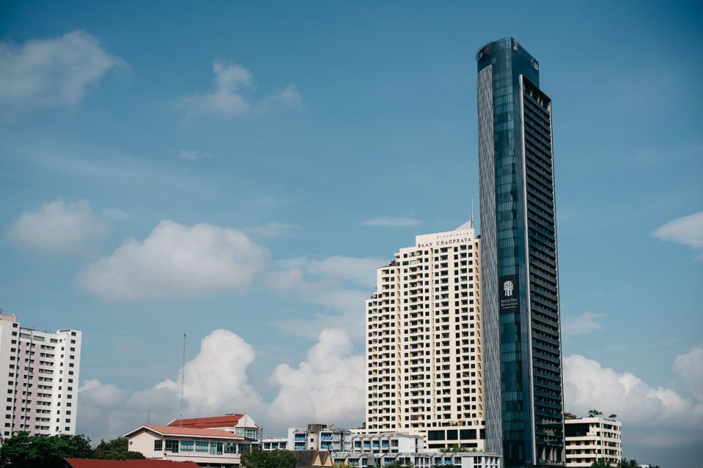 Panoramic view of Bangkok skyline featuring iconic high-rise buildings under a clear blue sky.