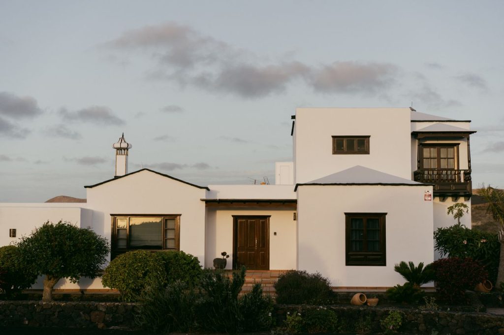 Elegant white villa with modern architectural design surrounded by lush greenery.