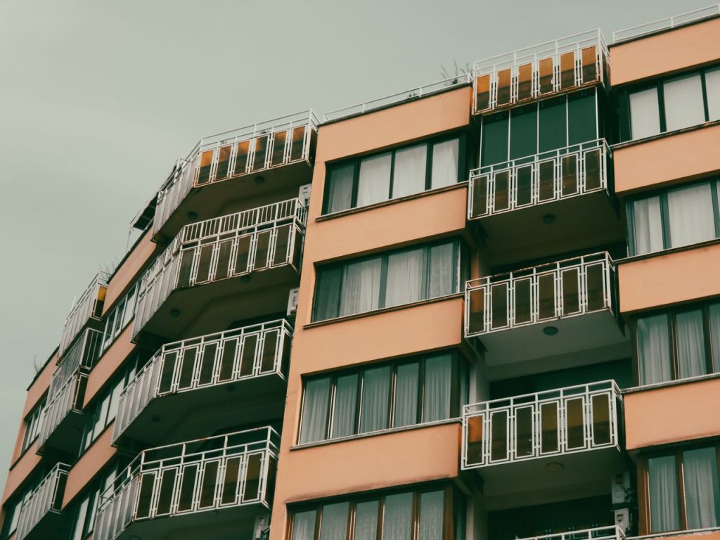 A contemporary apartment building with balconies in an urban setting.